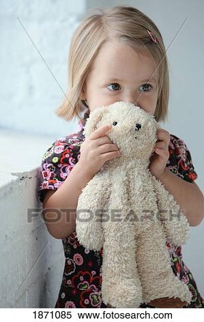 a young girl holding her teddy bear View Large Photo Image Stock Photography - a young girl holding her teddy bear. Fotosearch