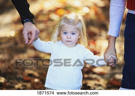 a young girl holding the hands of her parents View Large Photo Image Picture - a young girl holding the hands of her parents. Fotosearch
