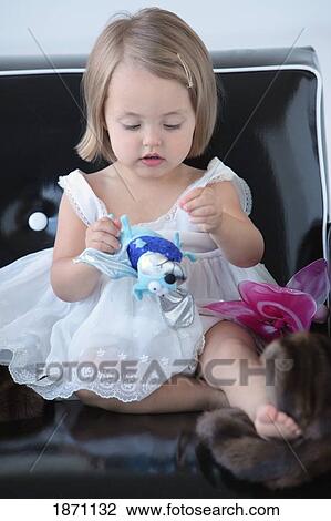 Stock Image - a young girl playing with her toys. Fotosearch