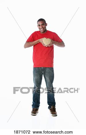 a young man holding a heart to his chest View Large Photo Image Stock Image - a young man holding a heart to his chest. Fotosearch