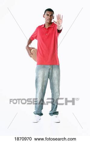 a young man holding out his hand to say stop with a heart held behind his back View Large Photo Image Stock Image - a young man holding out his hand to say stop with a heart held behind his back. Fotosearch