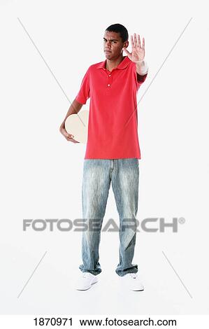 a young man holding out his hand to say stop holding a heart behind his back View Large Photo Image Stock Image - a young man holding out his hand to say stop holding a heart behind his back. Fotosearch