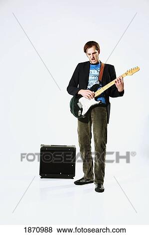 Stock Photo - a young man playing an electric guitar. Fotosearch