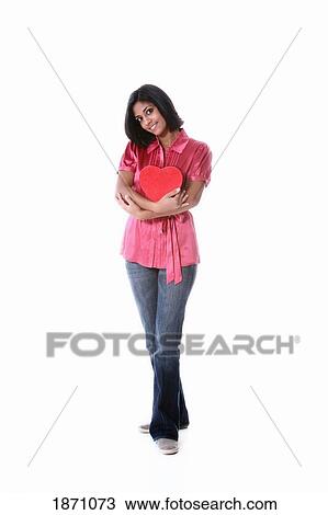 Stock Image - a young woman holding a heart. Fotosearch