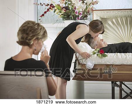a young woman kissing a loved one in a coffin at a funeral View Large Photo Image Stock Photo - a young woman kissing a loved one in a coffin at a funeral. Fotosearch