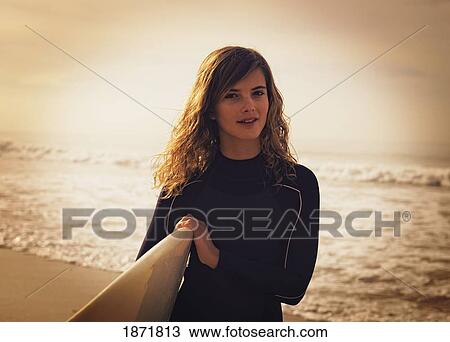 a young woman with her surfboard at the beach View Large Photo Image Stock Image - a young woman with her surfboard at the beach. Fotosearch