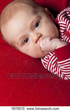 an infant wearing red and white and sucking on her fist View Large Photo Image Stock Image - an infant wearing red and white and sucking on her fist. Fotosearch