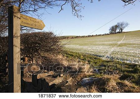 Stock Photo - bamburgh, northumberland, england; a wooden distance sign saying 'public footpath'. Fotosearch