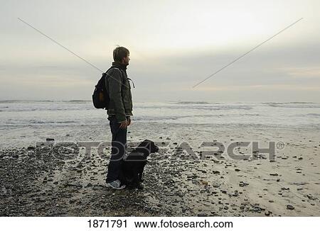 cadiz, andalusia, spain; a man on arte y vida beach with his black labrador dog at tarifa, costa de la luz View Large Photo Image Stock Image - cadiz, andalusia, spain; a man on arte y vida beach with his black labrador dog at tarifa, costa de la luz. Fotosearch