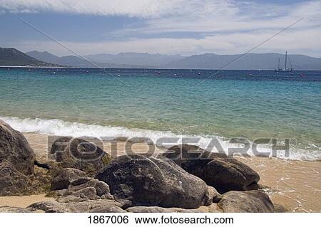 corsica, france; beach on the shoreline and the coastline in the background View Large Photo Image Stock Photograph - corsica, france; beach on the shoreline and the coastline in the background. Fotosearch