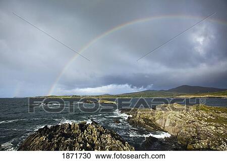 Stock Image - county cork, ireland; a rainbow in the sky near schull in west cork. Fotosearch