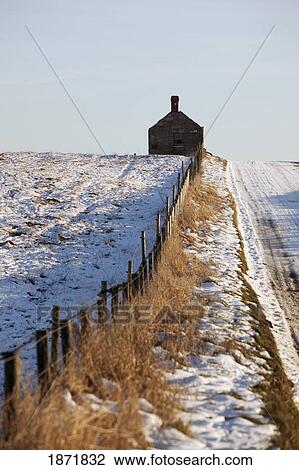 Stock Image - cresswell, northumberland, england; a snow covered road leading to a house. Fotosearch