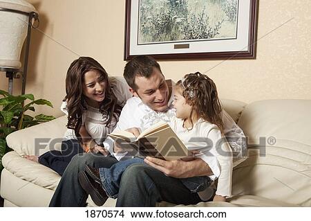 fort lauderdale, florida, united states of america; a mother and father reading a book to their daughter View Large Photo Image Picture - fort lauderdale, florida, united states of america; a mother and father reading a book to their daughter. Fotosearch