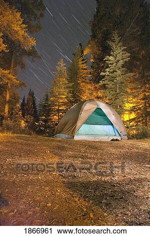 Stock Image - jasper national park, alberta, canada; light in a dome tent at night with star trails. Fotosearch