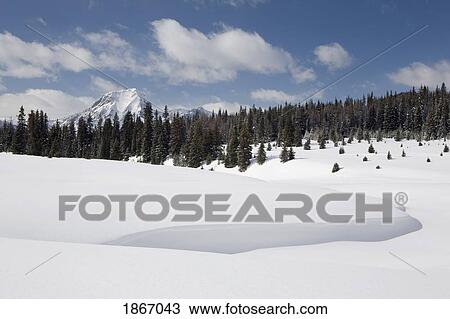 Stock Image - kananaskis country, alberta, canada; snow drifts and mountains. Fotosearch