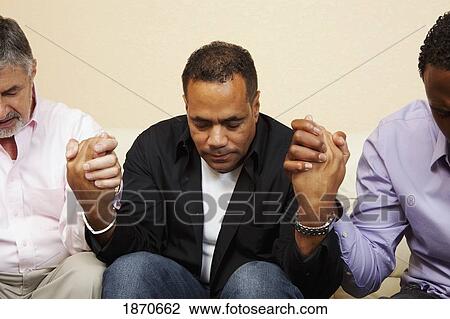Stock Image - men praying together. Fotosearch