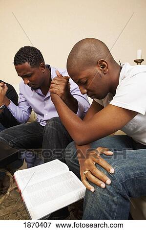 men praying together with an open bible View Large Photo Image Stock Photo - men praying together with an open bible. Fotosearch