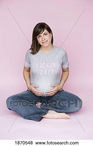 nashville, tennessee, united states of america; a pregnant woman sitting down with her hands on her belly View Large Photo Image Stock Photo - nashville, tennessee, united states of america; a pregnant woman sitting down with her hands on her belly. Fotosearch