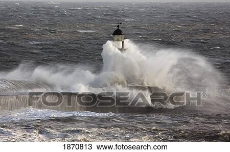 Stock Image - seaham, teesside, england; waves crashing on a lighthouse in the ocean. Fotosearch