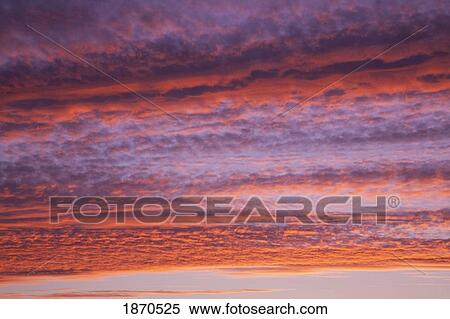 Stock Photography - shades of red and orange in the clouds at sunset. Fotosearch
