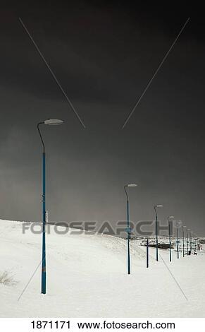 Stock Image - south shields, tyne and wear, england; light posts in the snow with a stormy sky. Fotosearch