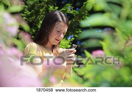 Stock Photo - teenage girl using her cellphone. Fotosearch