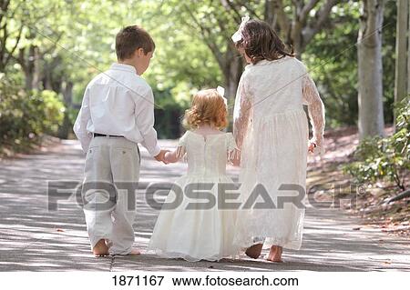 Stock Photo - three siblings walking and holding hands. Fotosearch