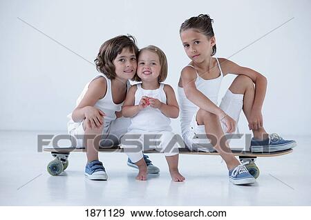 three young girls sitting on a longboard View Large Photo Image Stock Photo - three young girls sitting on a longboard. Fotosearch