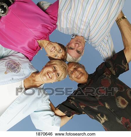 Stock Photograph - two men and two women with their heads together. Fotosearch