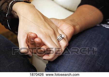 Stock Photograph - two women's hands clasped for prayer. Fotosearch