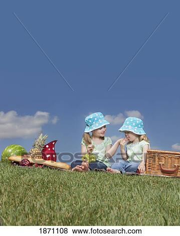 two young girls eating at a picnic View Large Photo Image Stock Photo - two young girls eating at a picnic. Fotosearch