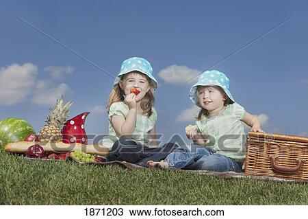 Stock Image - two young girls having a picnic. Fotosearch