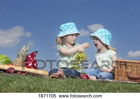 two young girls sharing grapes at a picnic View Large Photo Image Stock Photography - two young girls sharing grapes at a picnic. Fotosearch
