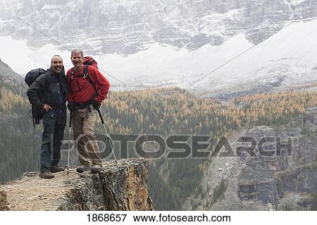 yoho national park, british columbia, canada; two male hikers standing on a cliff in the autumn View Large Photo Image Stock Photo - yoho national park, british columbia, canada; two male hikers standing on a cliff in the autumn. Fotosearch