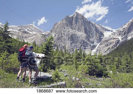 Stock Photo - yoho national park, british columbia, canada; a couple hiking through the mountains and looking at a map. Fotosearch