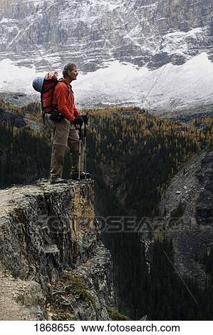 Stock Photography - yoho national park, british columbia, canada; a male hiker standing on a cliff in autumn. Fotosearch
