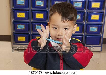 young boy holding a crayon in his hands View Large Photo Image Stock Image - young boy holding a crayon in his hands. Fotosearch