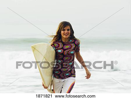 young woman running with her surfboard View Large Photo Image Stock Image - young woman running with her surfboard. Fotosearch