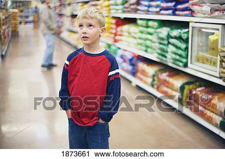 a boy looking around in a grocery store View Large Photo Image Stock Image - a boy looking around in a grocery store. Fotosearch