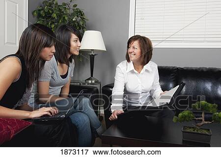 a businesswoman showing a document to two young women View Large Photo Image Stock Photo - a businesswoman showing a document to two young women. Fotosearch