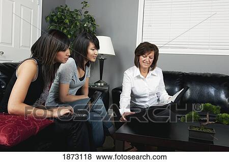 a businesswoman showing a document to two young women View Large Photo Image Stock Photo - a businesswoman showing a document to two young women. Fotosearch