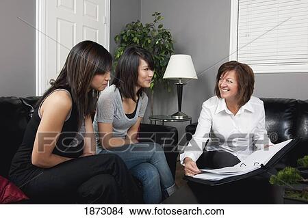 a businesswoman showing two young women a document View Large Photo Image Picture - a businesswoman showing two young women a document. Fotosearch
