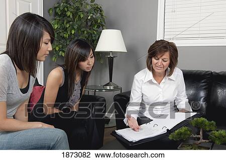 a businesswoman showing two young women a document View Large Photo Image Stock Image - a businesswoman showing two young women a document. Fotosearch