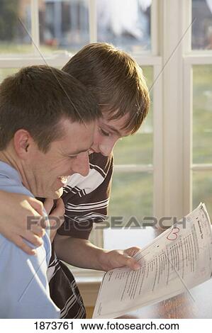 Stock Image - a father and son looking at school work. Fotosearch