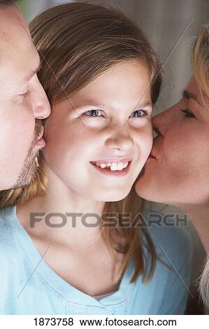 a mother and father kissing their daughter's cheeks View Large Photo Image Stock Photo - a mother and father kissing their daughter's cheeks. Fotosearch