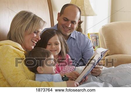 a mother and father reading with their children at bedtime View Large Photo Image Picture - a mother and father reading with their children at bedtime. Fotosearch