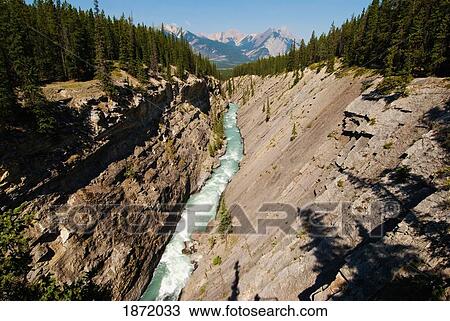 Stock Image - a river running through a canyon with mountains in the background. Fotosearch