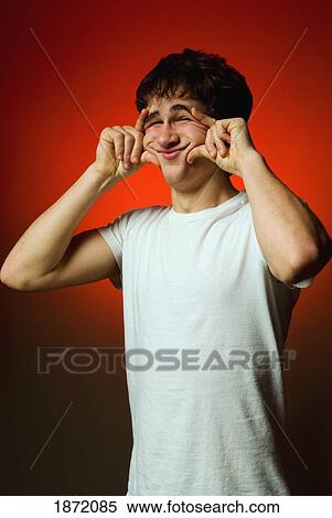a teenage boy making a silly face View Large Photo Image Stock Photography - a teenage boy making a silly face. Fotosearch