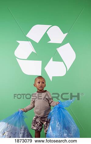 a young boy with bags of recycle items under a recycling sign View Large Photo Image Stock Photo - a young boy with bags of recycle items under a recycling sign. Fotosearch