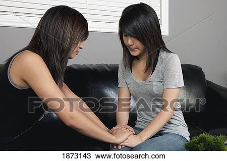 Stock Image - a young woman praying for a friend. Fotosearch